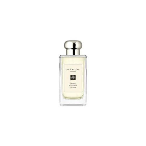 Jo_Malone_Orange_Blossom_2 Przejrzysty flakon Jo Malone Orange Blossom 100 ml na tle kwitnącego, słonecznego ogrodu cytrusowego.