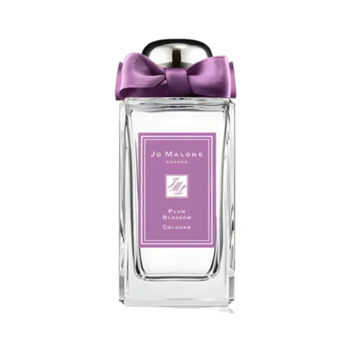 Jo_Malone_Plum_Blossom_2 Elegancki flakon Jo Malone Plum Blossom 100 ml otoczony białymi i różowymi płatkami kwitnących drzew.